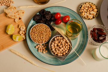 dates, lentils, chickpeas on a plate next to a glass of tea