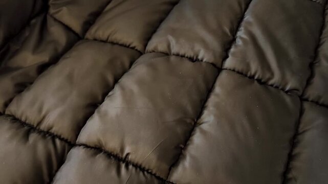 Black fabric with quilting and polyester filling for sewing warm clothes, down jacket. Lining