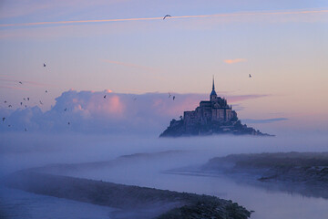 Obraz premium sunrise over the abbey of mont-saint-michel in normany france with fog