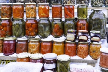 Pickles, lots of glass jars with mushrooms, vegetables, home jams. Pickled products on the market. Homemade pickles. Winter Food market in Shuya, Ivanovo Region, Russia