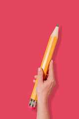 Hand Holding Giant Yellow Pencil on Vibrant Pink Background. Perfect Surreal Concept for Back to School Promotions, Educational Campaigns, Art School, DIY and Creative Learning Visuals