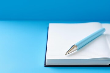 Blue pen resting on a blank lined notebook with space for copy
