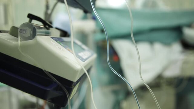 Timelapse shot of anesthesia equipment in a hospital operating room with surgical procedure blurred in background