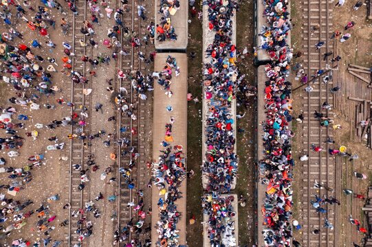 Tongi, Bangladesh - 12 January 2020: Aerial view of densely packed commuters atop and around trains at Tongi Rail Station Road, a sea of humanity amidst the tracks.