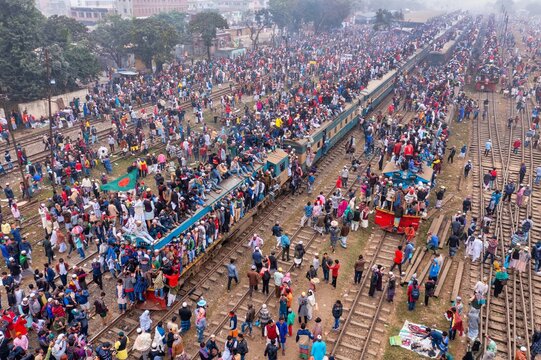 Tongi, Bangladesh - 12 January 2020: Aerial view of a crowded train at Tongi Rail Station, teeming with people atop and around, contrasting against railway tracks.