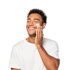 Happy young man applying a refreshing face cream, enjoying his daily skincare routine