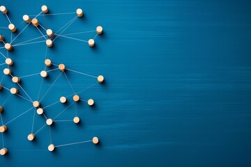 Wooden pegs connected by strings on a blue surface, forming a complex network