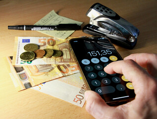 Haciendo cuentas y llevando contabilidad con dinero y calculadora