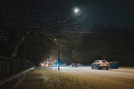 It is snowing in the city at night