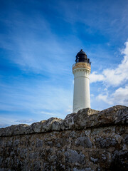 Lossiemouth lighthouse standing tall behind weathered stone wall