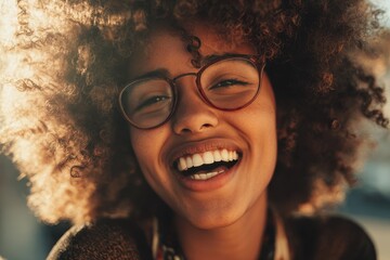 Portrait of a laughing African American girl with an afro and glasses facing the camera