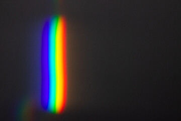 Abstract rainbow light spectrum on dark background, prism refraction effect