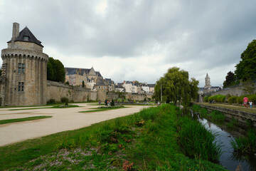 Historic medieval ramparts of Vannes overlooking landscaped gardens, with stone walls and traditional houses under a dramatic sky, showcasing Breton heritage, urban fortifications, and the harmony bet