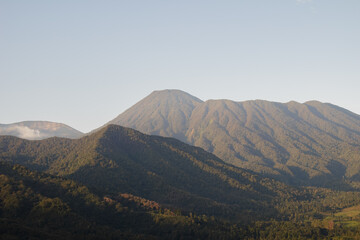Fototapeta premium Mountain landscape in Indonesia with forested hills and clear sky copy space