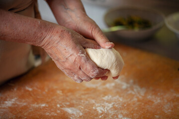 Women's hands make pasty dough