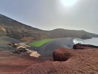 Lanzarote volcanic Lake and ocean beach in El Golfo, Canary Islands, Spain, tourism in the Canaries. Charco de los Clicos