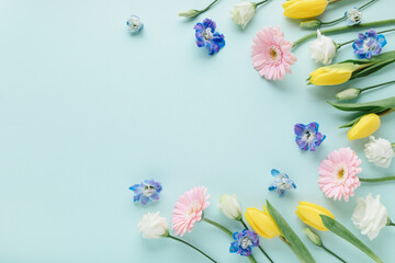 Bouquet of beautiful spring flowers on pastel blue table top view. Greeting card for International...