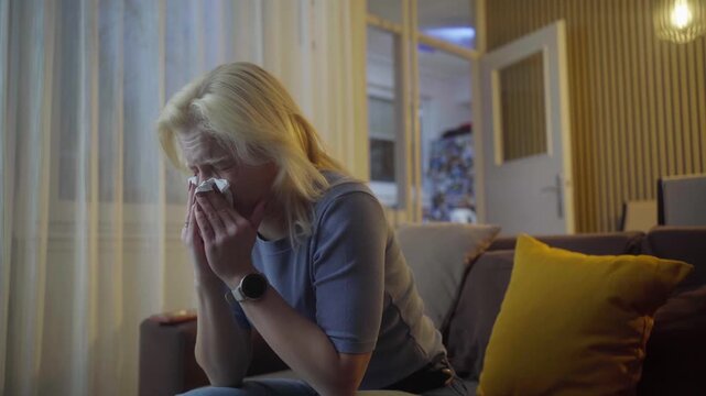 Blowing nose, tissue and sick with woman on sofa for flu season, pneumonia infection and illness. Hayfever, sneeze and allergy with person in living room at home for recovery, disease and cold