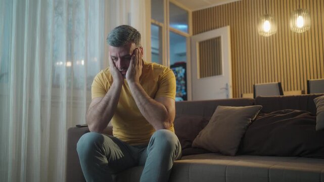 Stress, thinking and man with doubt in home for depression, reflection and worry for financial crisis. Anxiety, sad and person in living room with concern for fail, mistake or mental health challenge