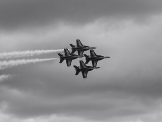 Naval Airshow, F-18 Super Hornet jets flying in formation on beautiful summer day high in the clouds