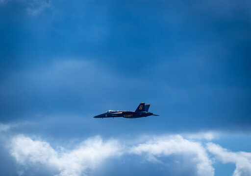 Naval Airshow, F-18 Super Hornet jets flying in formation on beautiful summer day high in the clouds - Powered by Adobe