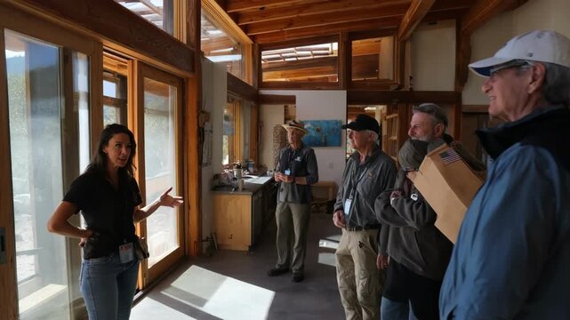 Specialist demonstrating shading techniques in passive solar homes ensuring comfortable indoor temperatures with adjustable overhangs and screens.