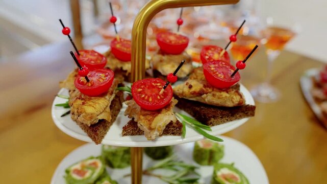 Refined tiered serving display holding gourmet canapes featuring grilled chicken, cherry tomatoes, rye bread, rosemary, highlighting culinary elegance at prestigious gathering