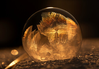 Zamrożona bańka mydlana, kryształy lodu w promieniach zachodzącego, zimowego słońca, tapeta. © mycatherina