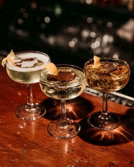Three Sparkling Cocktails with Lemon Garnish on a Wooden Bar