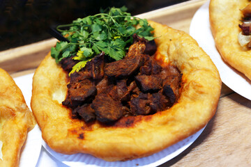 Freshly baked traditional hungarian langos langosch langosh with paprika beef for sale