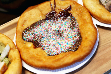 Freshly baked traditional hungarian langos langosch langosh with chocolate cream and colorful sweet drag&eacute;es for sale