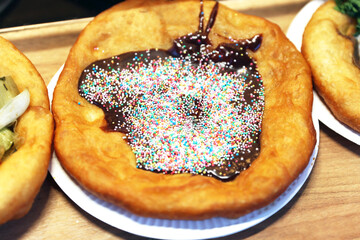 Freshly baked traditional hungarian langos langosch langosh with chocolate cream and colorful sweet drag&eacute;es for sale
