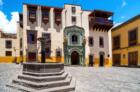 Casa de Col&oacute;n with decorated entrance, balcony and fountain in cobbled courtyard under sunlight in Vegueta