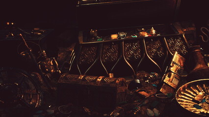 Glimmering gold and priceless gems spill from an ancient chest, resting amid relics of a forgotten era. This magical moment captures the thrill of discovery in a dimly lit cavern. © icetray