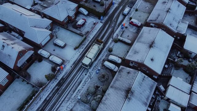 Drone. UK dustbin collection, garbage truck, snowy winter weather. 