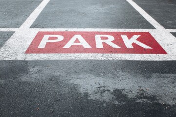 Parking space marked with red paint on asphalt at a public parking lot in the city during daylight hours