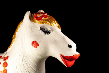 The face of a white toy horse with big red lips