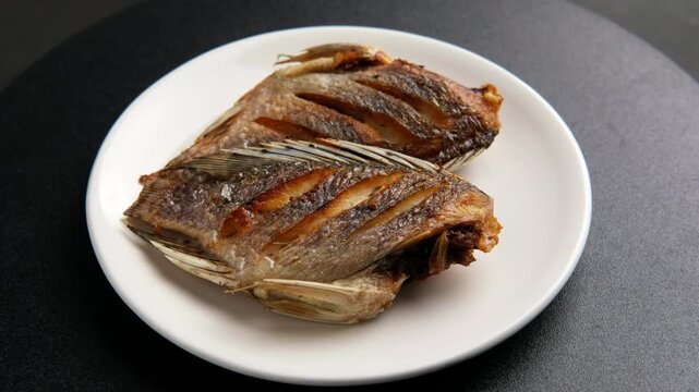 Fried Sun dried tilapia fish in a plate.