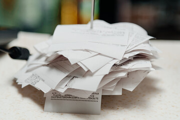 pile of spiked papers, restaurant and bar checks with orders on bar counter