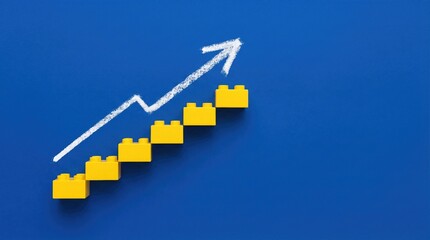 Ascending steps made of yellow toy bricks with upward white arrow on blue