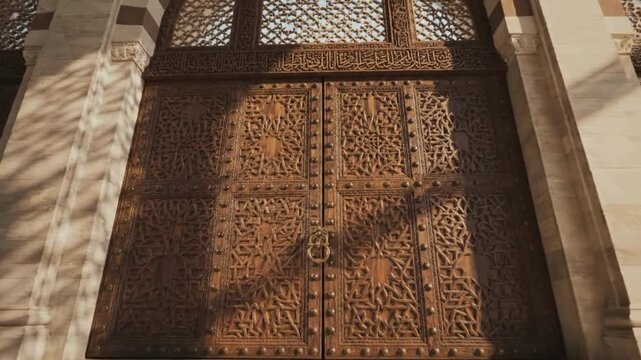 Islamic architecture grand entrance wooden door with geometric patterns and brass knocker in turkey