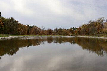 The peaceful pond in the park on a cloudy autumn day.