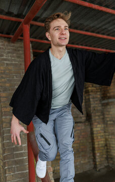 Casual young man moving and waiting in an urban industrial interior
