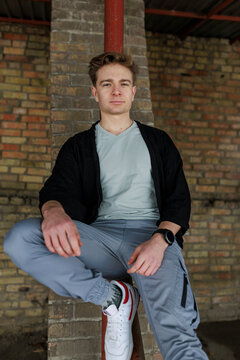 Casual young man moving and waiting in an urban industrial interior