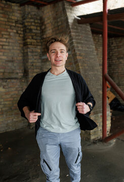 Casual young man moving and waiting in an urban industrial interior