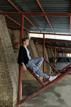 Casual young man moving and waiting in an urban industrial interior