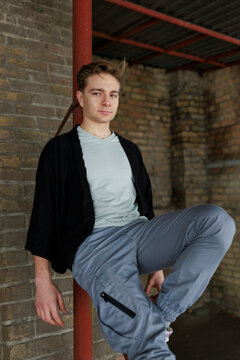 Casual young man moving and waiting in an urban industrial interior