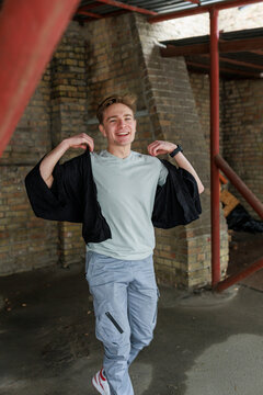 Casual young man moving and waiting in an urban industrial interior