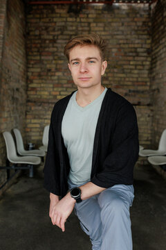 Casual young man moving and waiting in an urban industrial interior