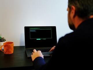 Middle Aged Systems Administrator Engineer Restoring Backups After Ransomware Hacking Attempt - Cybersecurity and Data Protection Concept